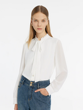 a lady in a white bow tie ruffle collar shirt